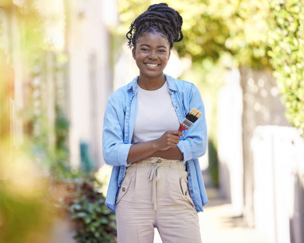 cropped shot of a woman holding a paintbrush - female house painter home decorator paintbrush imagens e fotografias de stock