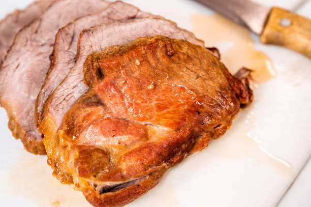 istock Baked pork neck, sliced to steak on kitchen board. 1385432555