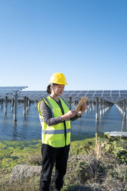 istock Female engineer using tablet at solar power plant in water 1385433473