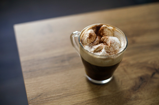 Mocha or Espresso con panna, coffee with whipped cream on a table.