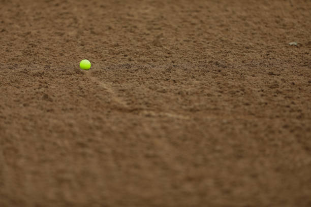 A yellow golf ball in a sand bunker
