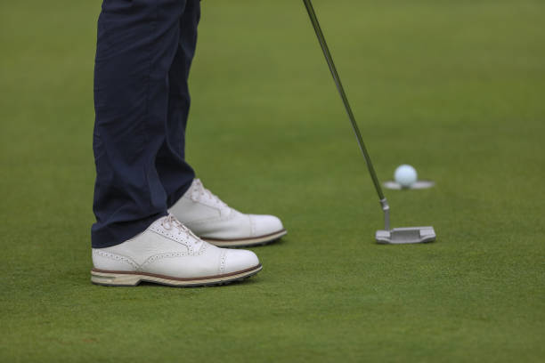 istock A close up of a golfers feet while he is putting on a golf course 1385433641