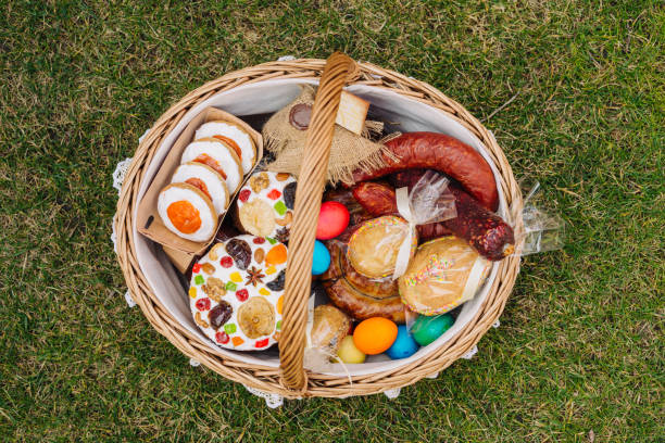 Easter basket with ukrainian easter cake, cookies and Easter eggs on green lawn, view from above. Easter item stock photo