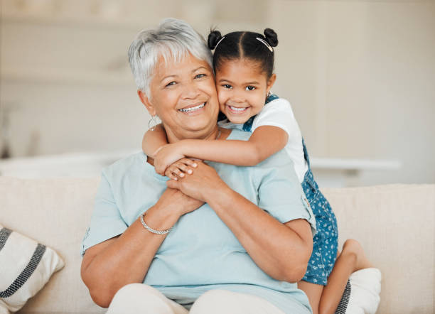 Shot of a grandmother and granddaughter bonding on the sofa at home Our family is a circle of strength and love hispanic grandmother stock pictures, royalty-free photos & images