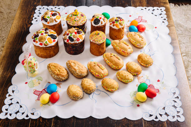 Traditional ukrainian easter Kulich cake, easter cookies of egg form in retro style, and Easter eggs on a wooden desk on embroidered handmade towel stock photo