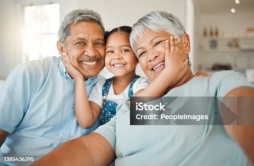 istock Shot of grandparents bonding with their granddaughter on a sofa at home 1385436395