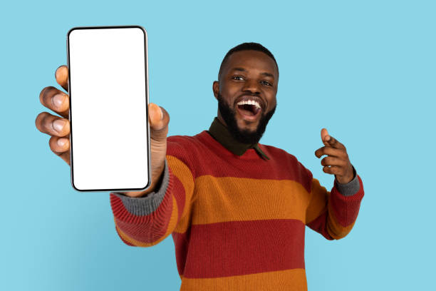istock Great App. Cheerful Young Black Man Demonstrating Blank Smartphone At Camera 1385439558