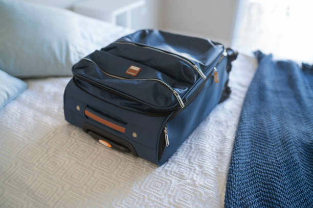 istock Carry-on luggage on  bed at hotel room 1385441773