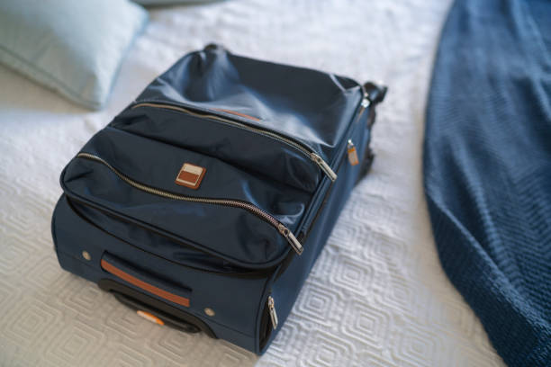 istock Carry-on luggage on  bed at hotel room 1385441777