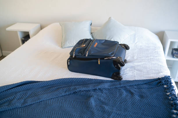 istock Carry-on luggage on  bed at hotel room 1385441793