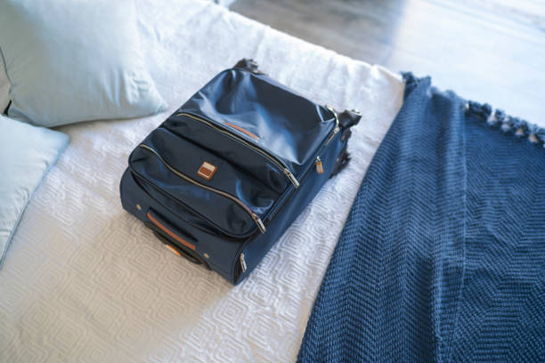 istock Carry-on luggage on  bed at hotel room 1385441803