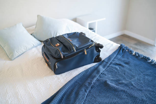 istock Carry-on luggage on  bed at hotel room 1385441808