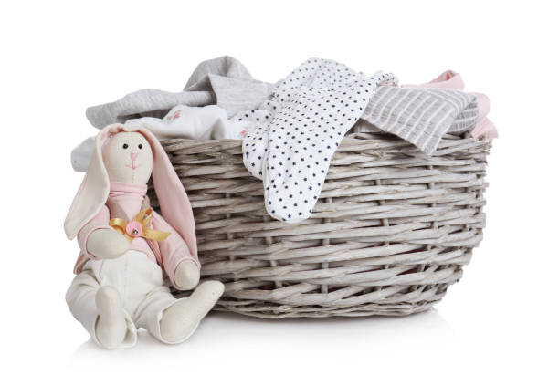 istock Wicker basket with baby clothes and bunny on white background 1385446334