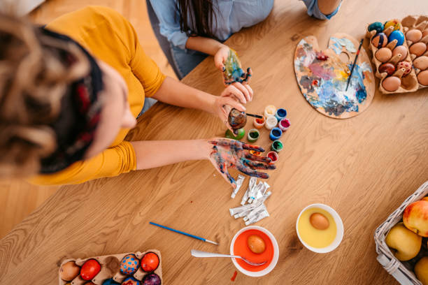 istock Two Young Women Painting Easter Eggs 1385451909