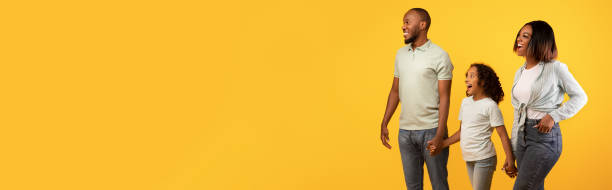 istock Excited black family looking at copy space on yellow, banner 1385453984