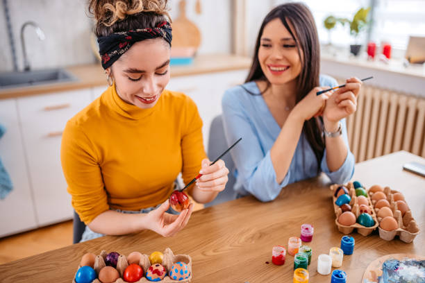 istock Two Young Women Painting Easter Eggs 1385455163