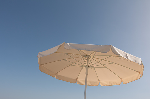 Big white parasol in front of a sunny blue sky