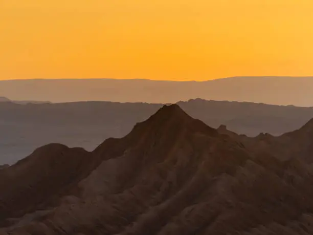 Photo of Stunning sunset in the Valle de la Luna (Valley of the Moon), San Pedro de Atacama, Chile. Amazing rock formations, deep canyons and cliffs, huge sand dunes with infinite color and texture variations.