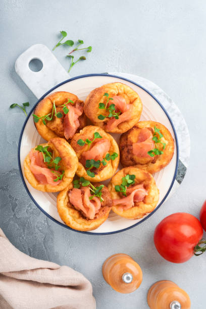 istock Yorkshire pudding. Traditional English Yorkshire pudding with salmon and radish microgreens side dish on white plate and light grey background table. Top view. 1385461138