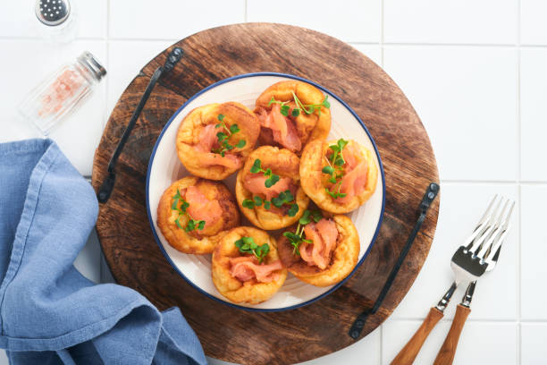 istock Yorkshire pudding. Traditional English Yorkshire pudding with salmon and radish microgreens side dish on white plate and light grey background table. Top view. 1385461324