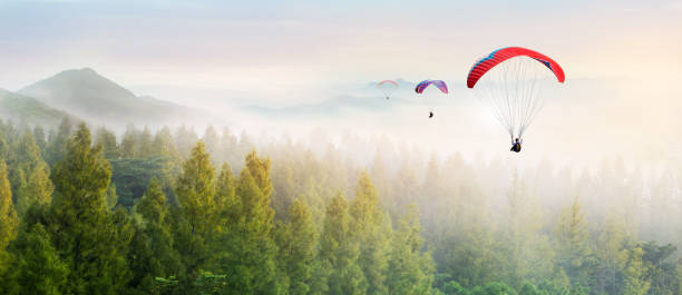 Paragliding in the sky. Paraglider  flying over Landscape sun set Concept of extreme sport, taking adventure challenge. Paragliding in the sky. Paraglider  flying over Landscape sun set Concept of extreme sport, taking adventure challenge. airborne sport stock pictures, royalty-free photos & images