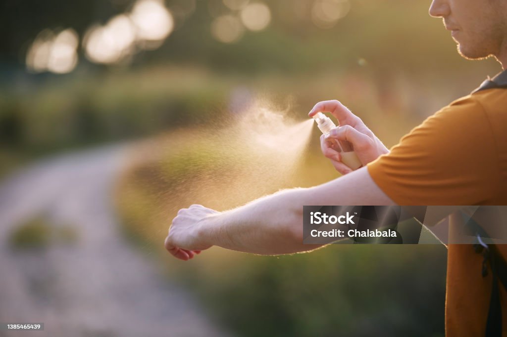 Man applying insect repellent on his hand Prevention against mosquito bite in tropical destination. Man applying insect repellent on his hand."n Dengue Fever - Fever Stock Photo