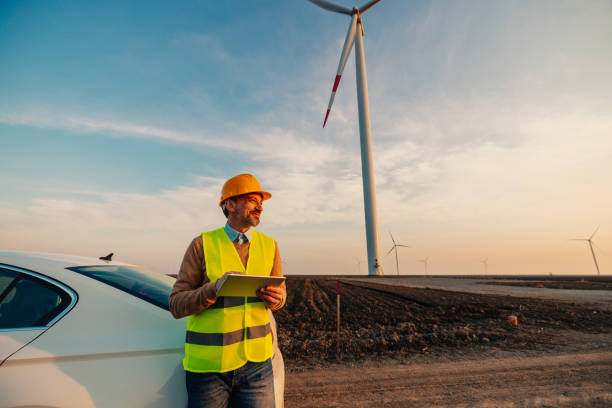 ingénieur masculin au champ d’éoliennes à l’aide d’une tablette - engineer wind turbine alternative energy energy photos et images de collection
