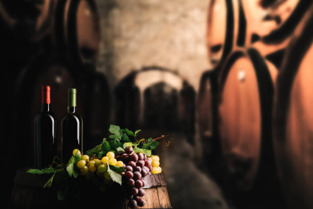 istock Wine bottles and a glass on a barrel 1385469192