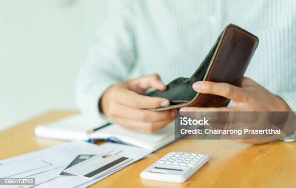 Close Up Man Hand Opening Empty Wallet Over Calculator Debt Expense Bills Monthly And Credit Card At The Table In Home Office Managing Payrollmoney Risk Financial Concept Stock Photo - Download Image Now