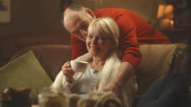 istock Senior husband covering wife with scarf 1385477018