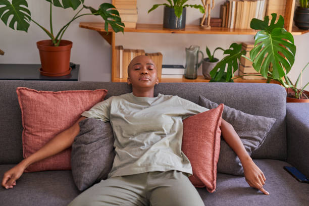 istock A young woman naps on the couch exhausted 1385479067