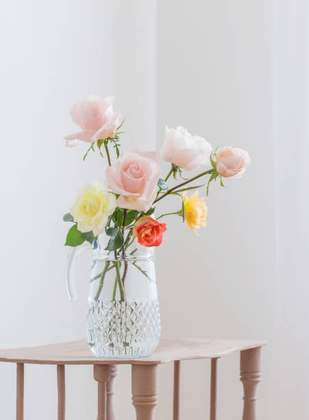istock beautiful roses in glass jug on white background 1385490327