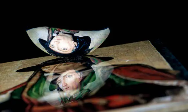 Photo of A classic renaissance portrait reflect from a tablet surface into a spoon