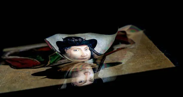 Photo of A classic renaissance portrait reflect from a tablet surface into a spoon