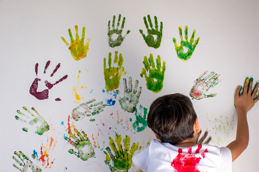 Boy plays with finger paint