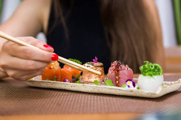 istock Woman eating delicious sushi 1385500848