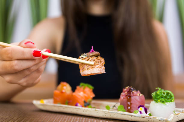 istock Woman eating delicious sushi 1385500891