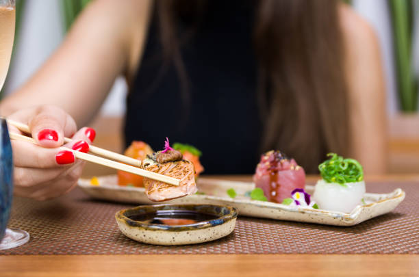 istock Woman eating delicious sushi 1385501570