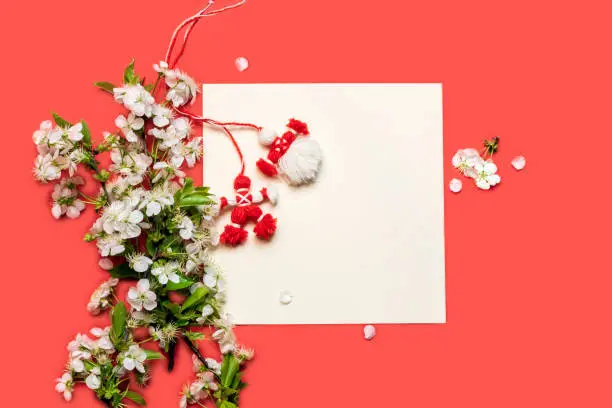 Martisor and cherry blossoms.On a red background.Symbol of Spring.March 1 Tradition.Copy space.