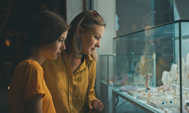 Family looking at the shop window of jewelry store. Family looking at the shop window of jewelry store. window shopping at night stock pictures, royalty-free photos & images