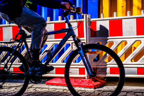 biker silhouette in front of a construction barrier - photo