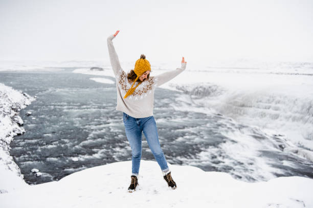 istock A cheerful woman at the Gulfoss Waterfall background 1385502304