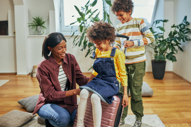 istock Mother and children having fun while packing for trip 1385502929