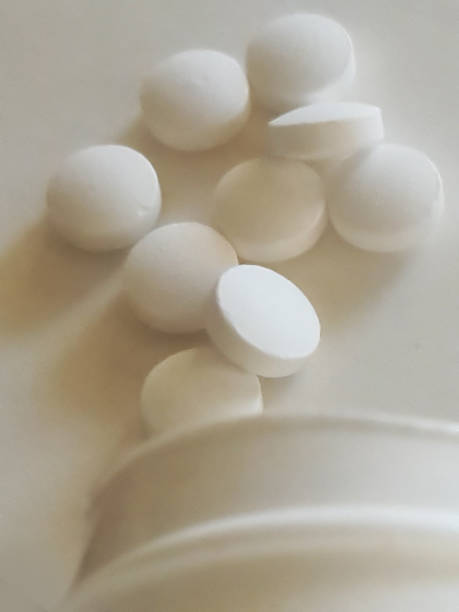 istock Medicine tablets spilled from the bottle on a white background 1385503279