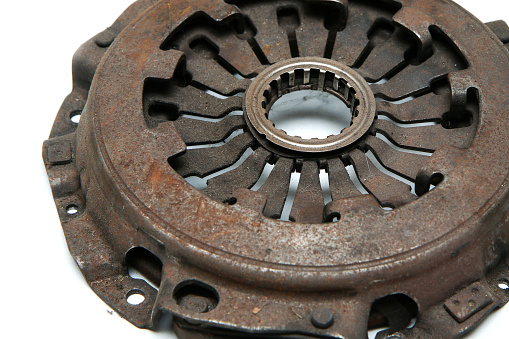 The old rusty used clutch from the car engine isolated in a white background. Has to be changed for new one.
