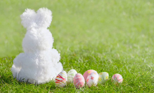 istock Happy Easter! Easter  eggs and cute bunny  on green grass in the  Meadow 1385503450