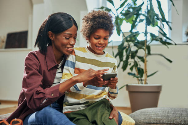 istock Mother and son using cellphone at home 1385504381