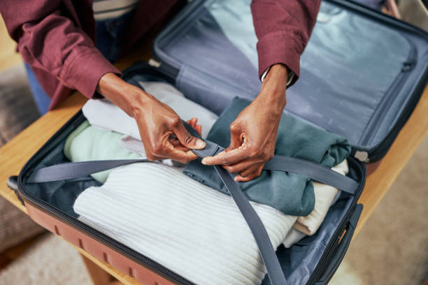istock Woman packing her clothes into a suitcase, getting ready for a trip. 1385506391