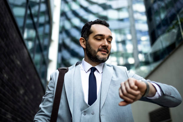 istock Serious businessman on a way to work looking at wristwatch 1385507986