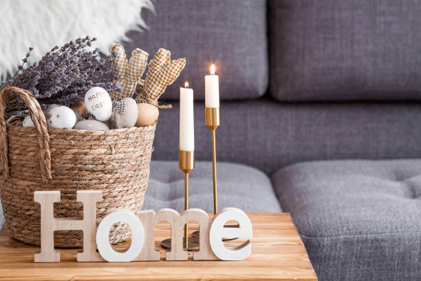istock Provence. A wicker basket with Easter eggs, lavender, candles and white rabbits in the interior of the living room on a wooden table. The concept of home comfort in the bright holiday of Easter 2022. 1385509005